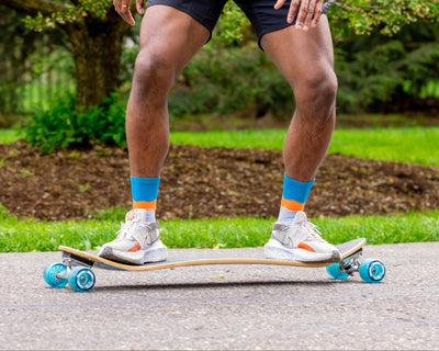 Man skateboarding in a park with greenery in the background