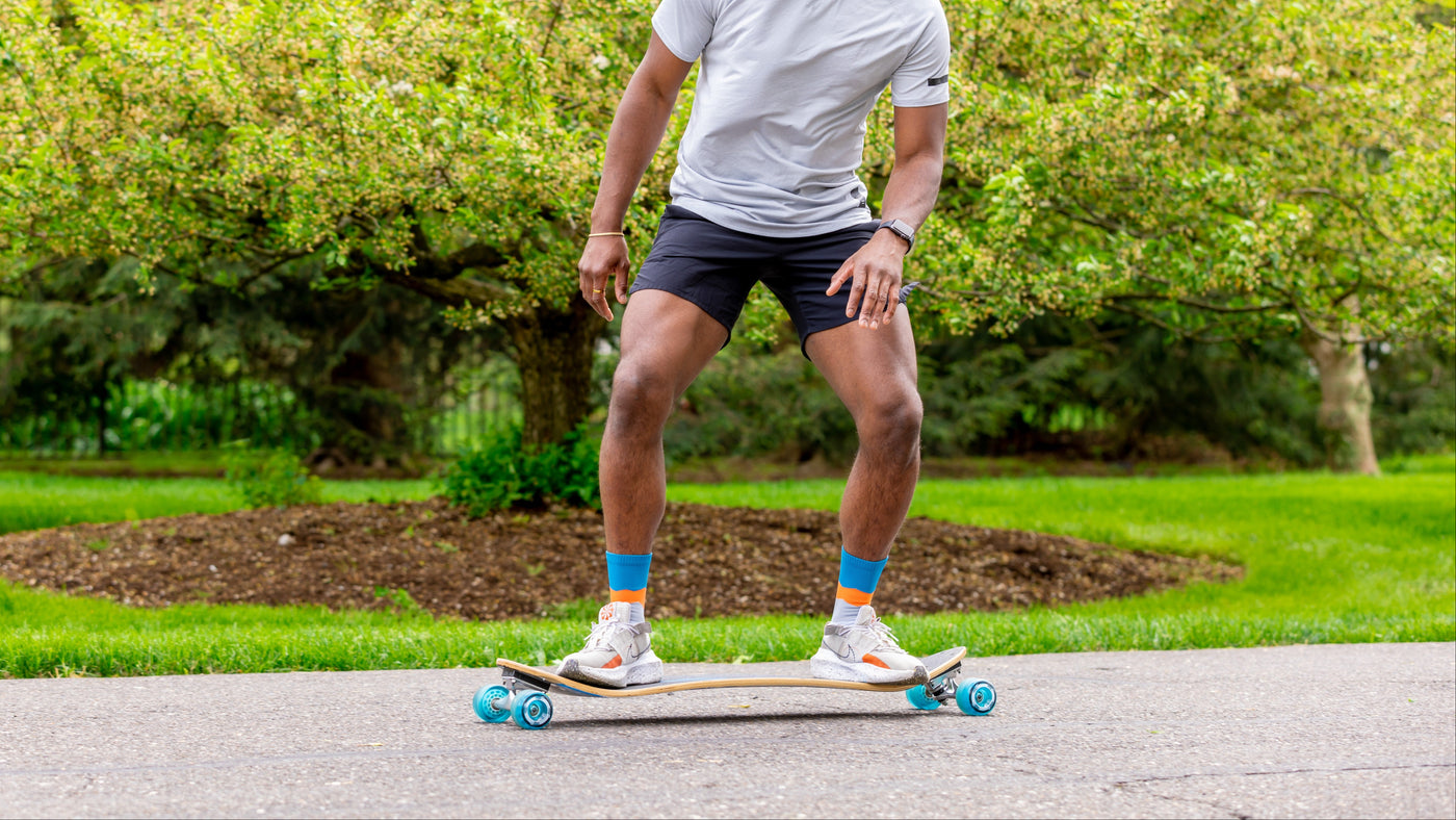 Man skateboarding in a park with greenery in the background grip perfromance crew 
